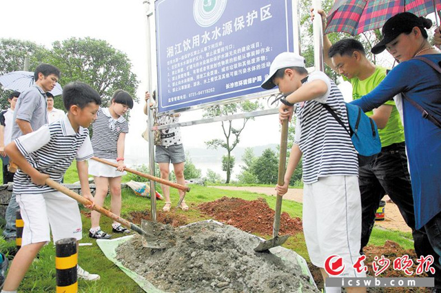 近日，在湘江风光带上，环保志愿者和中小学生共同将饮用水水源保护区标志竖立起来。  均为陈飞 摄