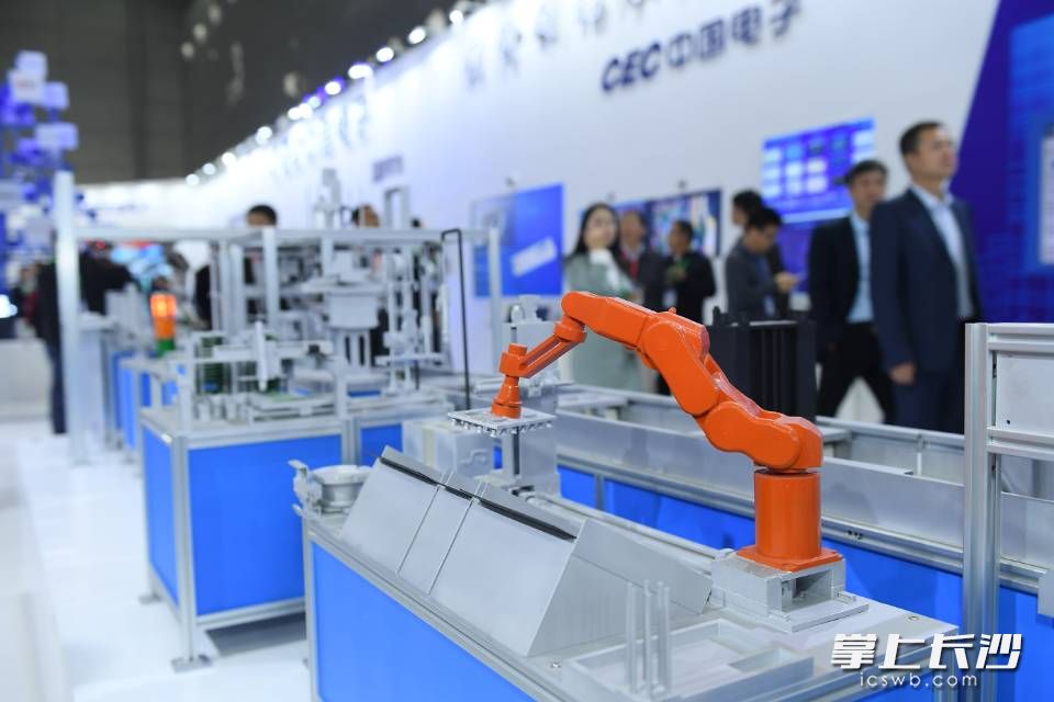 在中国电子展区，一台橘黄色的机器人正精准地演示抓取等动作。