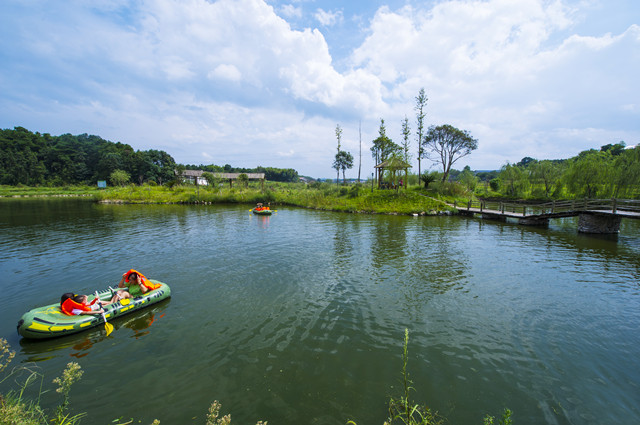 在白沙镇双冲村的小湖里，游客们正在体验皮划艇。