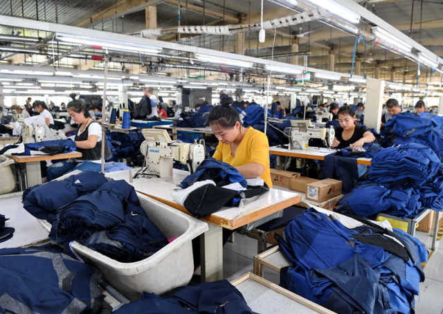 　　4月18日工人在容城县津海服装工业园生产车间内工作。新华社记者 牟宇 摄