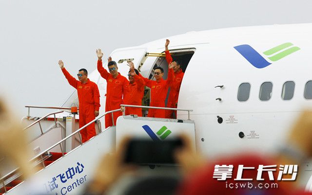 C919客机完成首飞，在上海浦东国际机场着陆后，首飞机组人员走出机舱向观礼嘉宾挥手致意。新华社记者 方喆 摄