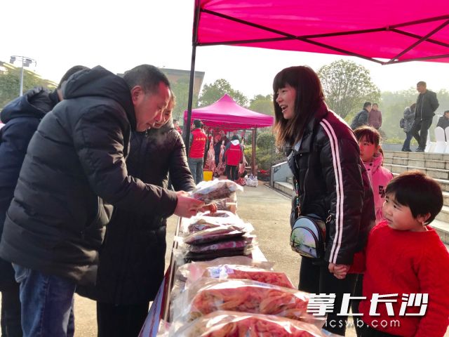 扶贫专干刘旺玲帮贫困户推销坛子菜、腊鱼等，她的女儿也来帮忙助阵。 长沙晚报全媒体记者  聂映荣 摄