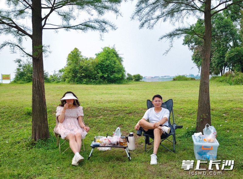 两人安静地坐在湖边品茶。
