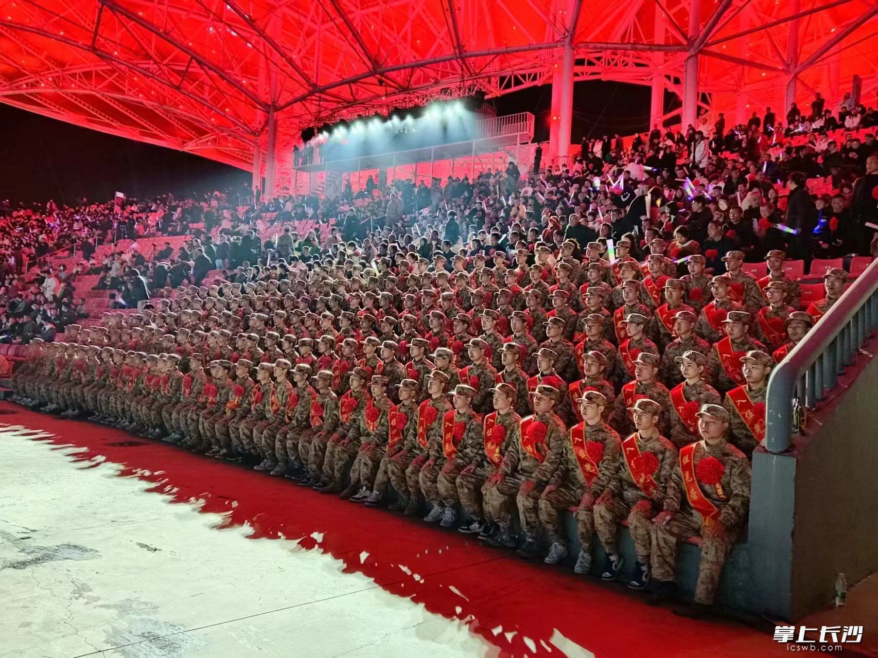 新兵们身着迷彩服，胸前佩戴着大红花，肩披“参军光荣”绶带，身姿挺拔、意气风发。