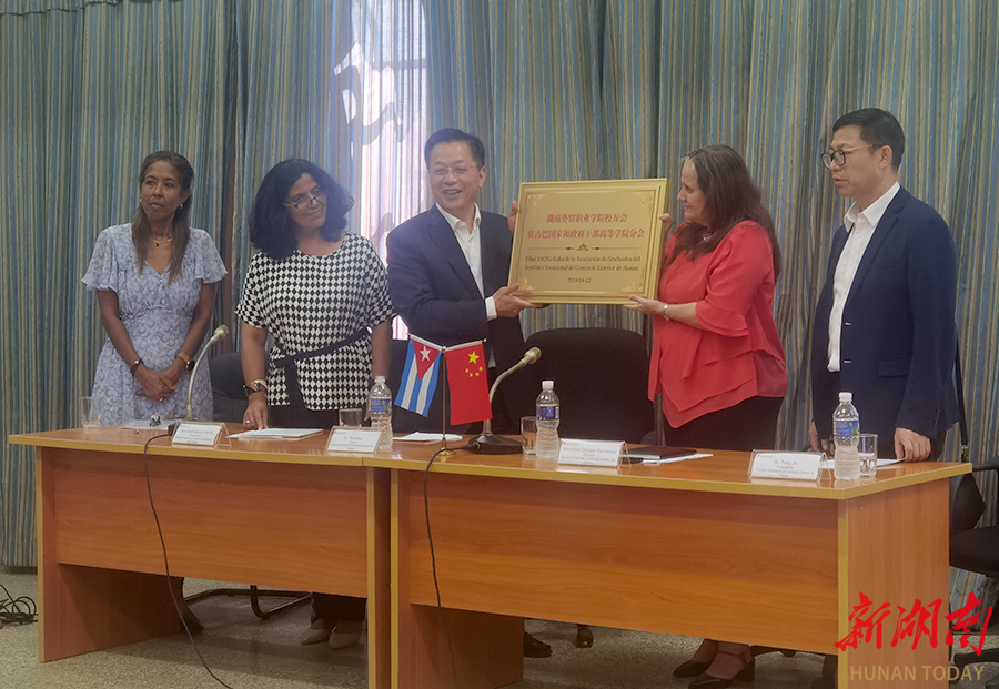 Xia Zhilun (3rd, L) conferred the plaque to the Cuban alumni branch of the Hunan International Business Vocational College.
