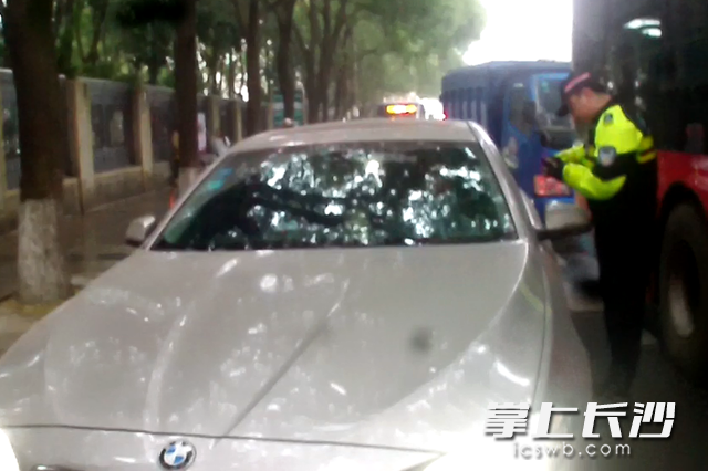 在蒋某驾驶的车辆前，民警敲打车窗约2分钟才将其叫醒。视频截图