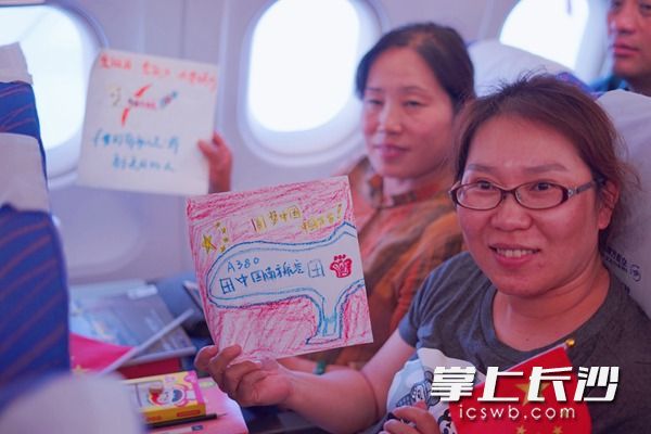 旅客在明信片上写下对祖国的祝福，庆祝祖国69岁华诞