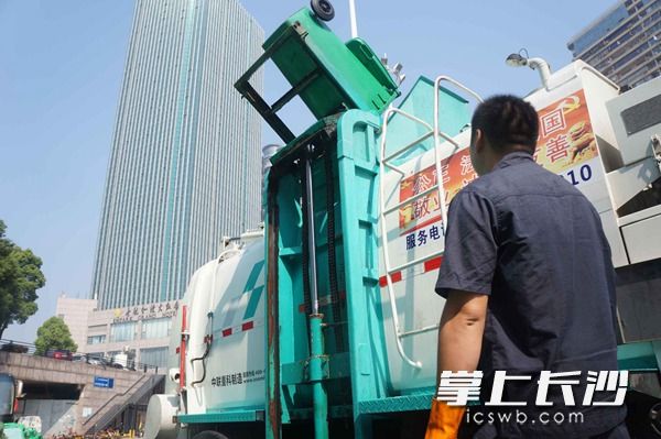 餐厨垃圾收集桶通过举升装置被自动倒入封闭式收运车内。