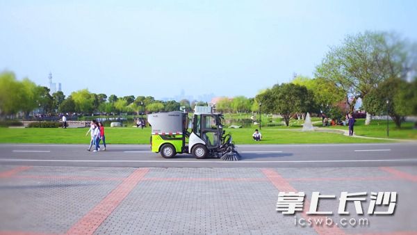 “无人小扫”实现无人驾驶清洁景区，吸引了市民研究。周辉霞 摄 