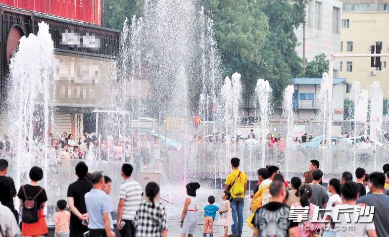 黄兴南路步行商业街南门口广场处的喷泉引来不少市民。