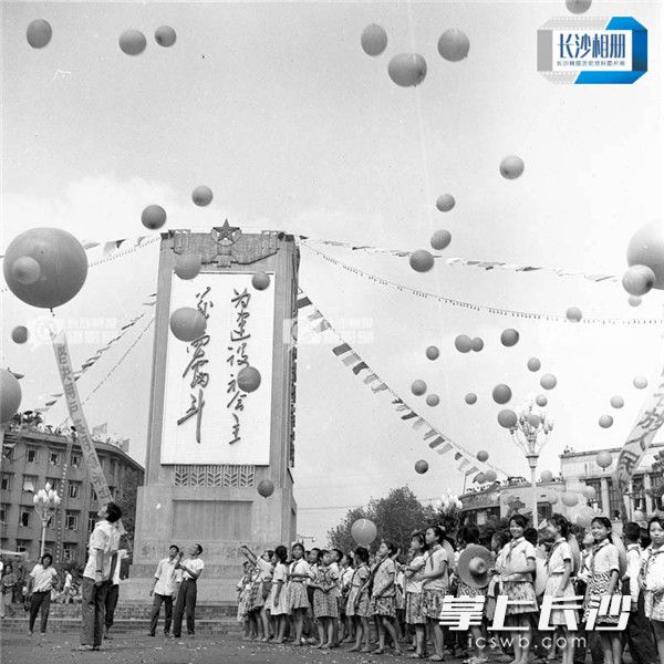 1977年8月，学生们来到五一广场举行庆祝活动，当年的五一广场花坛中心有“为建设社会主义而奋斗”标语的语录碑。