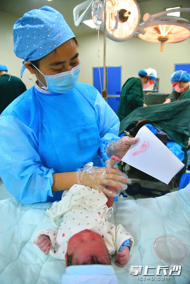 张湘玲为刚出生的宝宝按脚印