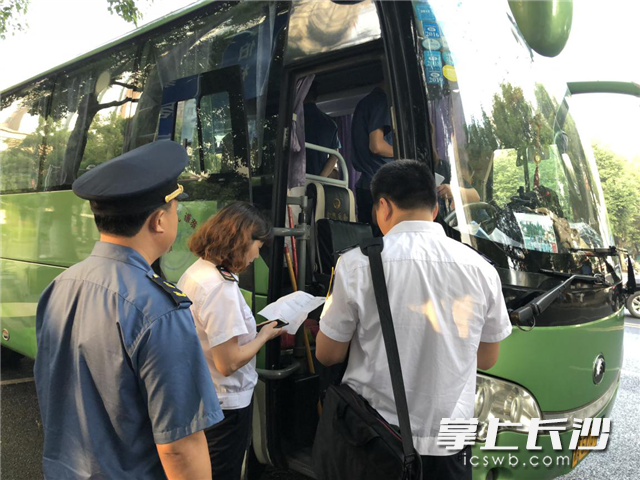 长沙旅游交通联合执法检查组人员在对旅游客运车辆和旅游团队服务质量情况进行检查。