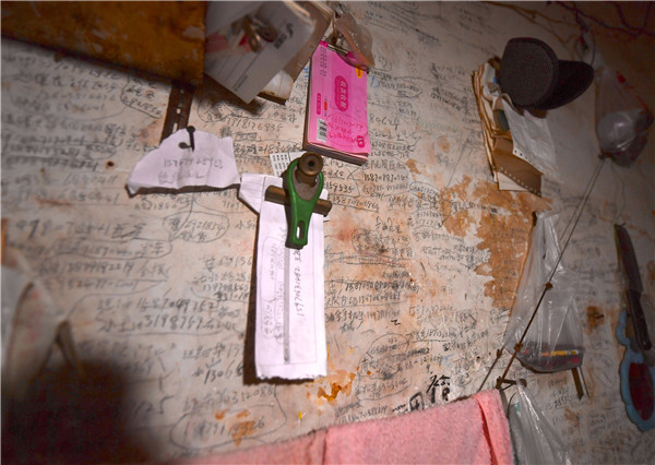 　　↑万佐成和熊庚香家中斑驳的墙壁上写满了10多年来患者和家属留下的电话号码（1月9日摄）。他们希望老两口今后也能去他们家中做客。