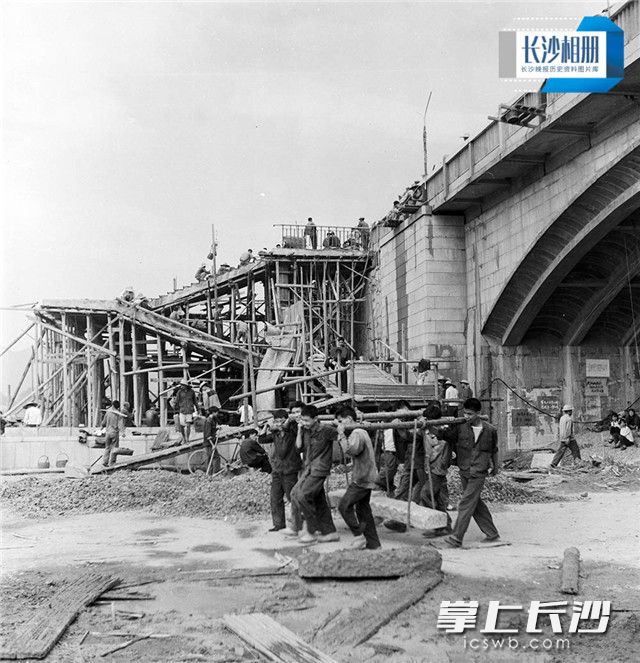 1972年，大桥建设工地上，长沙市民纷纷前来义务帮忙挑土运石。湘江一桥于1971年9月开工修建，到1972年国庆便竣工通车，前后只用了一年时间。