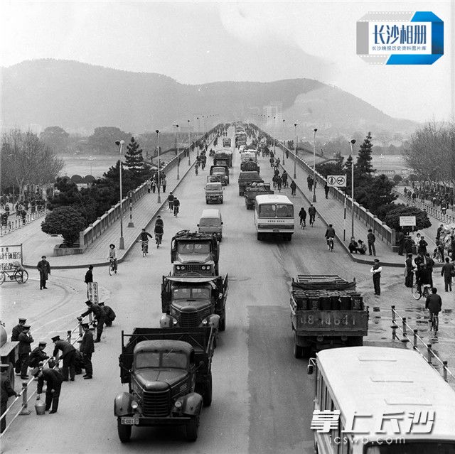 1984年3月1日，施工人员正在给五一大道加装栏杆，那时通行湘江一桥的交通工具通以货车、公共汽车和自行车为主。