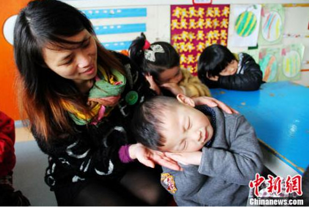 资料图：图为幼儿园老师正在教儿童学“睡觉”。李建平 摄