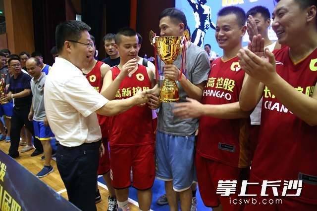 在欢乐开心的气氛中，高新区党工委委员、总工会主席杨金林（前排左一）为冠军球队进行颁奖。陈丹妮 摄