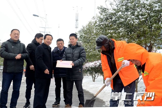 周庆年（左三）代表高新区，为一线抗击冰雪者送上慰问金。周秋燕 摄