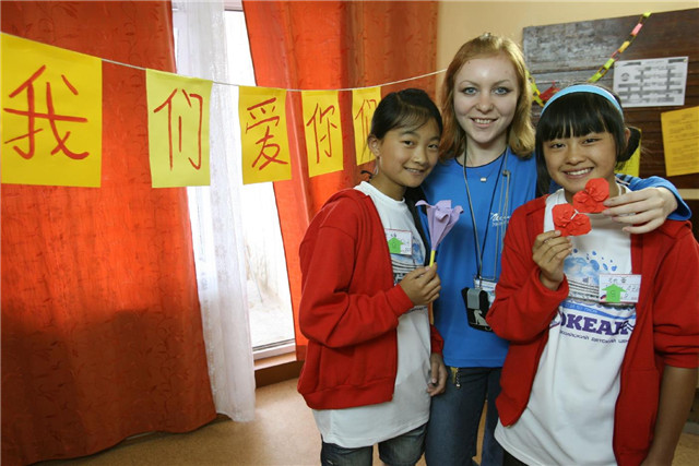 2008年7月21日，在“海洋”全俄儿童中心，两个中国小姑娘和她们的折纸课老师合影留念。新华社记者 郑悦 摄