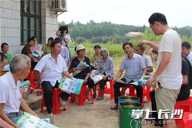 在资福镇清泉河村的户主动员会上，镇联村干部正在向村民们介绍“三个一点”分类减量法，并现场派发垃圾分类桶。