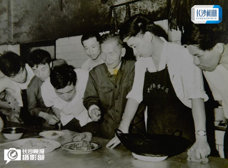 湖南省最早的一级厨师舒贵卿（中）正在向王墨泉（右一）传经授艺。