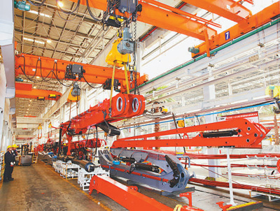 图为三一重工智能制造车间，工人正在远程操控臂架翻转智能吊具（资料图片）