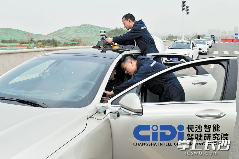 在位于湖南湘江新区的智能系统测试区内，工作人员正在调试一台接受智能驾驶检测的轿车。该智能系统测试区将于6月30日正式对外开放。 　　长沙晚报记者 王志伟 摄
