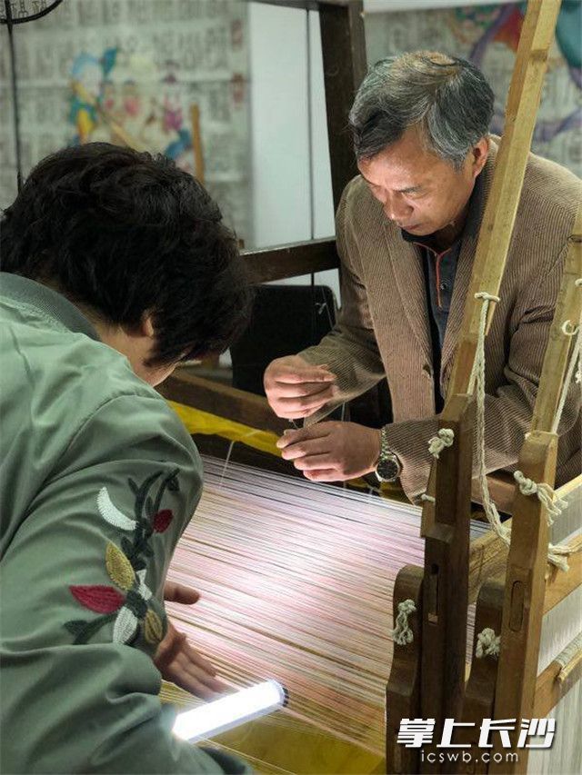 江苏省非物质文化遗产传人、南京市工艺美术大师杨建顺和助手正在调试机台。