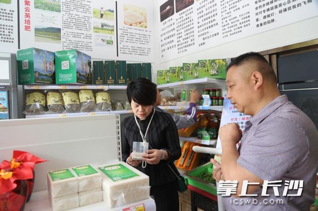 周灯文（右一）向顾客介绍茶亭餐宝的特色农产品。尹成洺 摄
