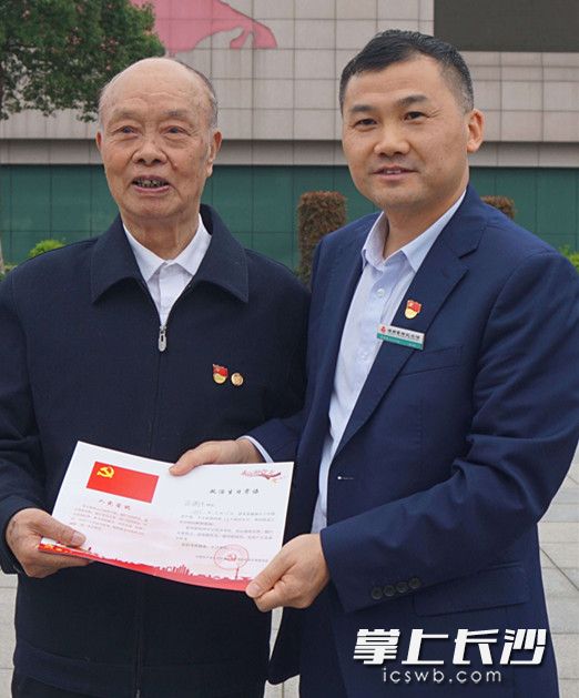 雷锋生前同事、老党员冯正其（左）与雷锋纪念馆党员互赠政治生日贺卡。