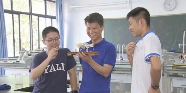 黄奕远（左一）和教练徐宏勇（中）正在讨论