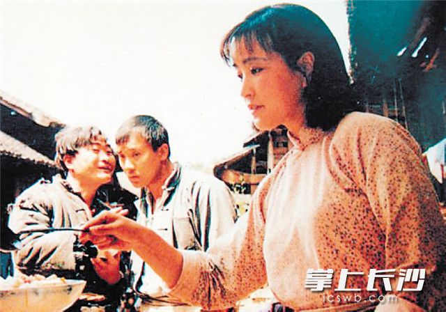 电影《芙蓉镇》剧照，刘晓庆在卖米豆腐。