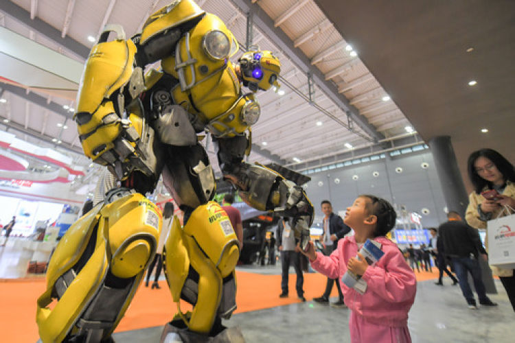 5月15日，在长沙国际工程机械展览会上，小朋友和机器人互动。 新华社发（陈泽国 摄）