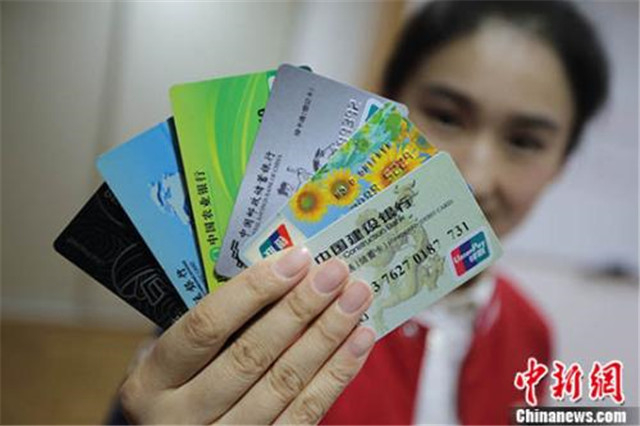 图为一位市民展示她所拥有的不同银行的银行卡。(资料照片) 中新社记者 泱波 摄