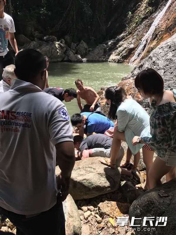 穿蓝色T恤的潘凯华正拼命在抢救溺水青年。游客沈曼平女士摄