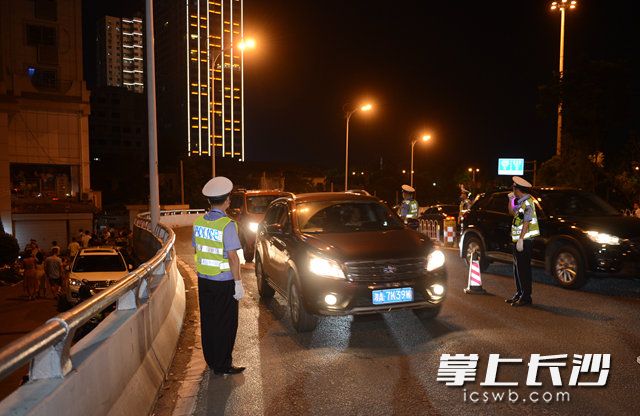 今晚，十余名驾驶人因不按规定使用灯光，在橘子洲大桥南匝道被交警拦下。照片均为长沙晚报记者 余劭劼 摄