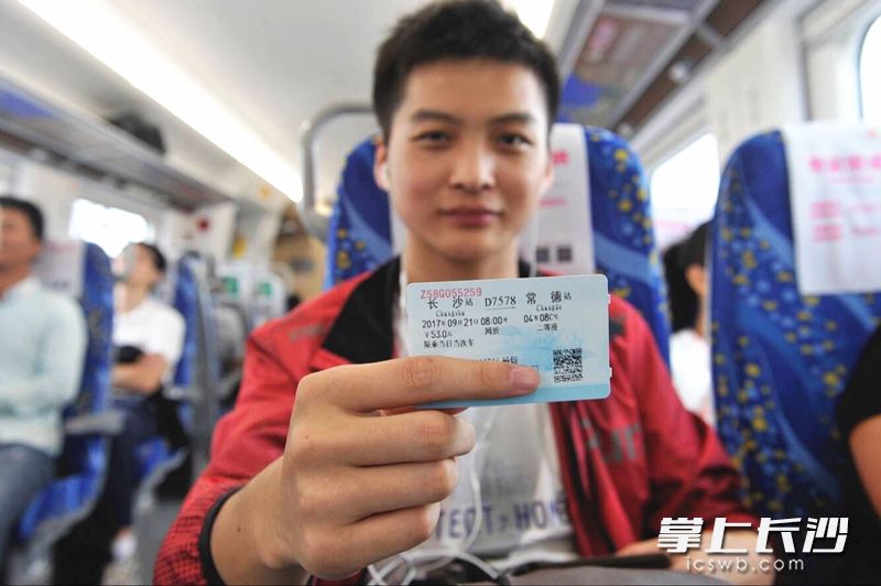 石长铁路动车组首批乘客展示车票。