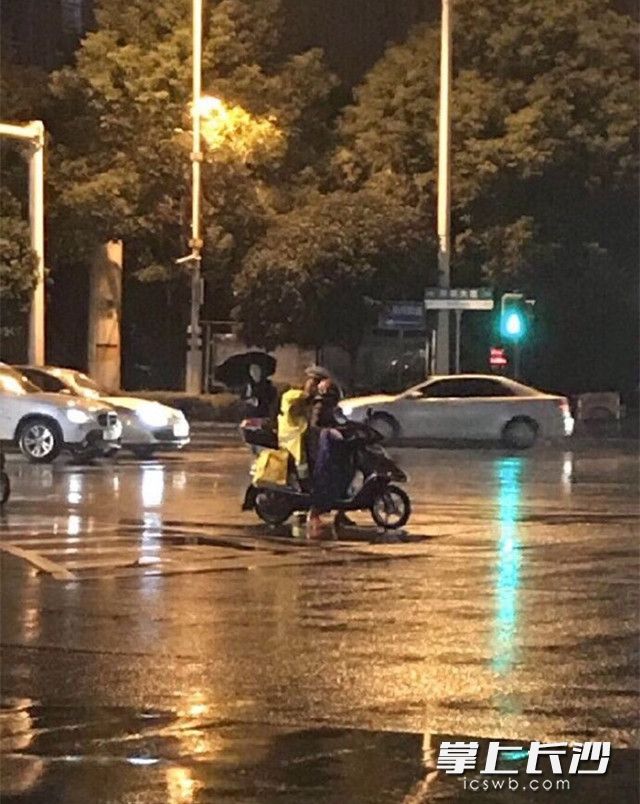 昨日18时20分左右，开福交警大队十中队协警王震见骑着电动车的母女淋湿，把自己的警用雨衣脱下给小女孩穿，自己冒雨执勤。市民拍摄