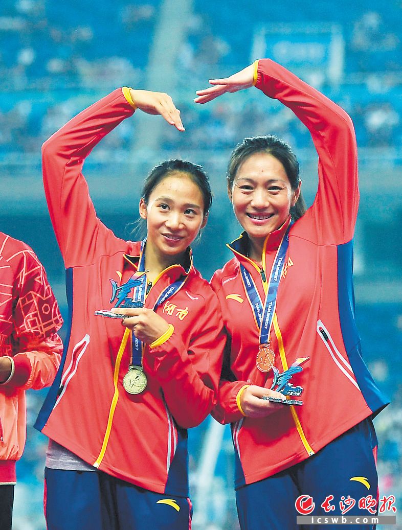 冠军湖南选手黄瑰芬（左）、亚军江苏选手袁琦琦比心庆祝。