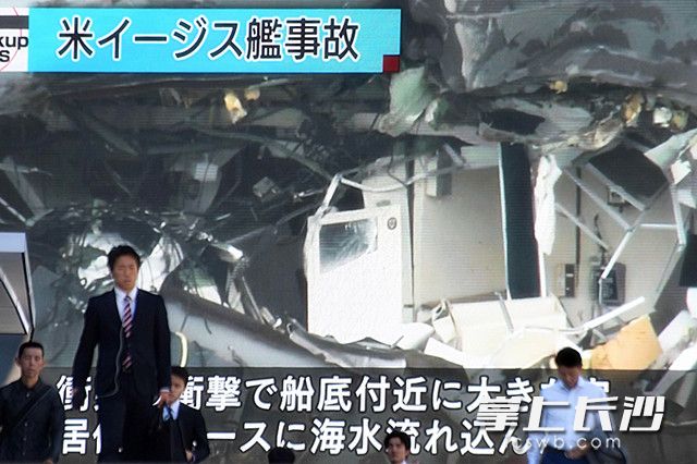 6月19日，在日本东京，行人经过正在播放美国军舰与菲律宾货船相撞事故的节目的电子显示屏。