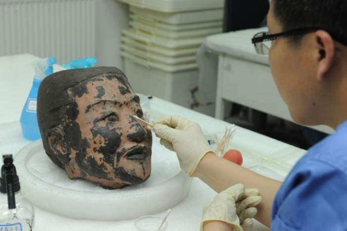 2012年6月9日，工作人员在西安秦始皇帝陵博物院文物保护实验室内对俑头进行清理。 新华社发（张天柱 摄）