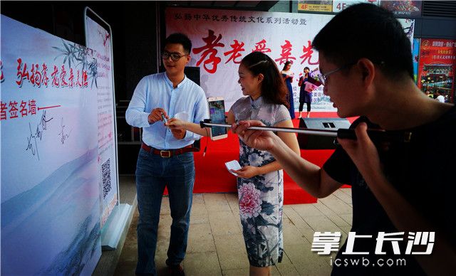 活动启动仪式上，两位文明主播在传播湖湘文化做文明市民的签名板上带头签名。