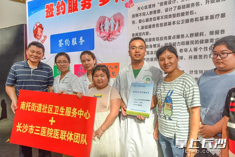 天心区社区居民李清波作为第一个与1+N“家庭医生组合签约服务团队”完成签约的家庭代表欢喜不已