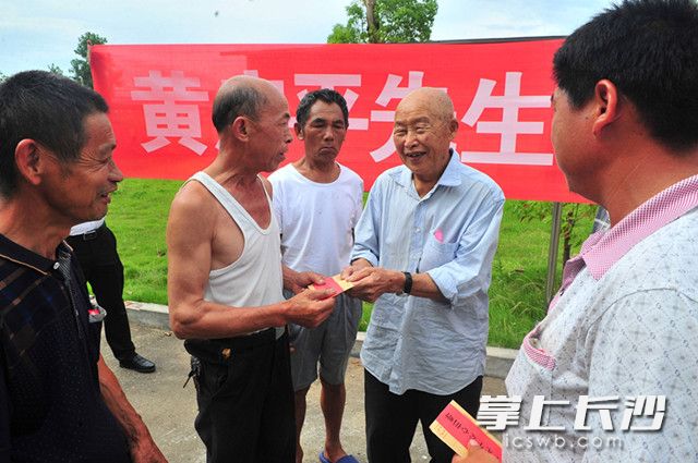 今日，黄启平88岁的父亲黄梅生代表儿子黄启平，将爱心款发给当地受灾农户。长沙晚报记者 贺文兵 摄