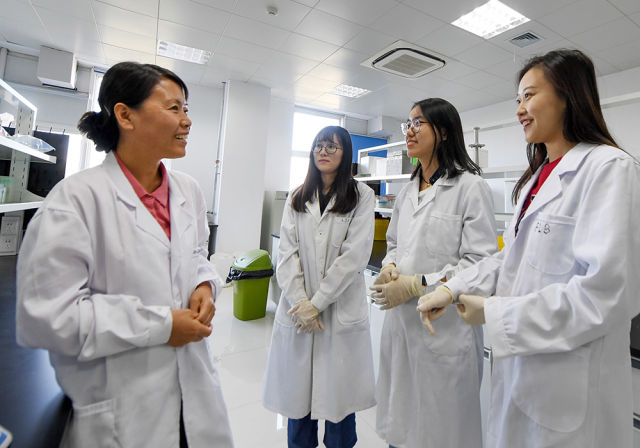　　9月28日，党的十九大代表、天津大学药学院党委书记冯翠玲(左一)和学生在实验室里交流。(新华社记者 白禹 摄)