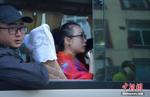 　　来自湖南的游客周女士(前)上车后边哭边用手机给家人报平安。