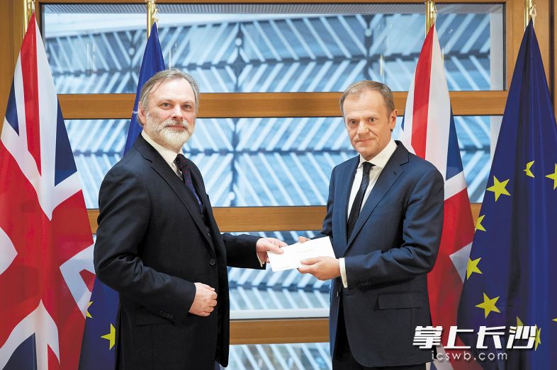 3月29日，在比利时布鲁塞尔，英国驻欧盟大使蒂姆·巴罗（左）将“脱欧”信函递交欧洲理事会主席图斯克。