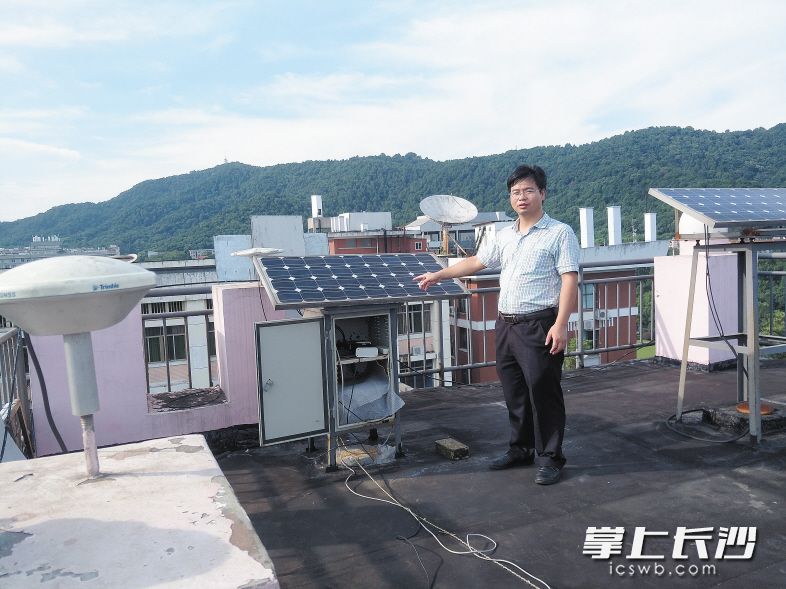 在中南大学的一座楼顶上，戴吾蛟向记者介绍“全球卫星导航系统变形监测技术”系统。 长沙晚报记者 詹春华 摄