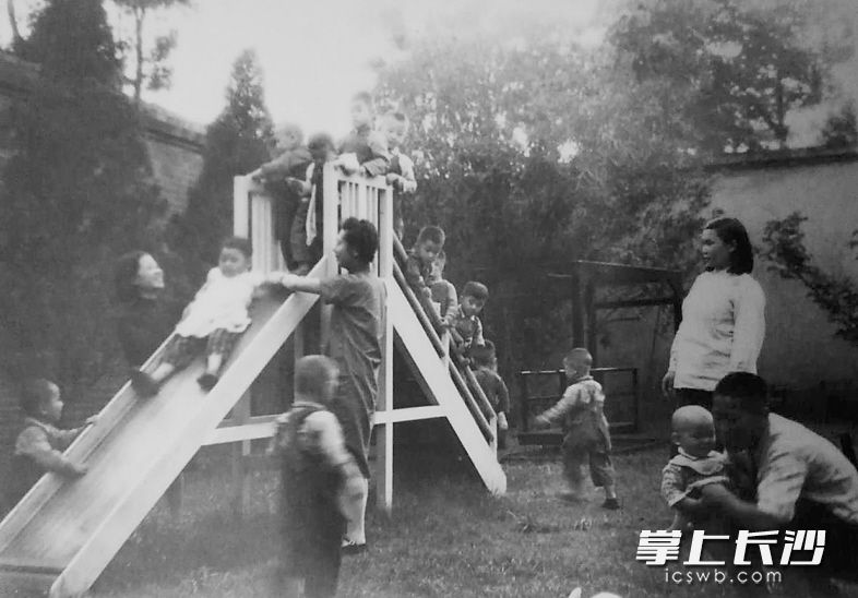 滑梯在长沙俗称“梭梭板”。这是上世纪50年代长沙一家托儿所内幼儿们在老师的看护下玩“梭梭板”。当时，长沙托儿所内儿童游戏设施并不多，但每一样都会让孩童们异常开心。